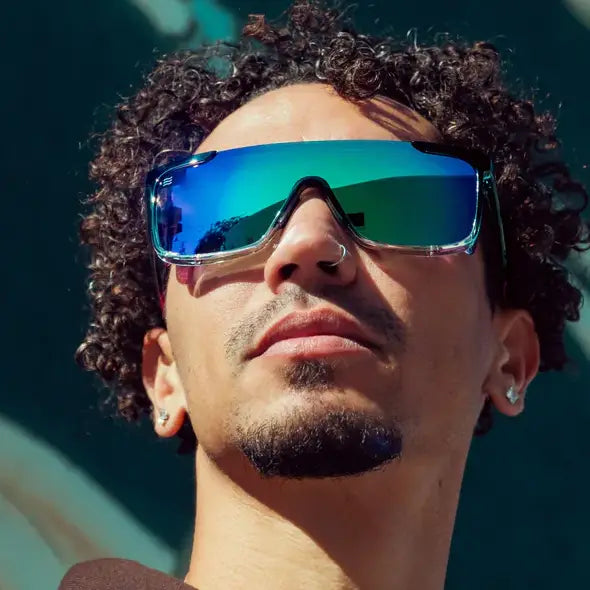 Person wearing Neven Night Watch polarized sunglasses with reflective blue-green shield lenses and black frames.