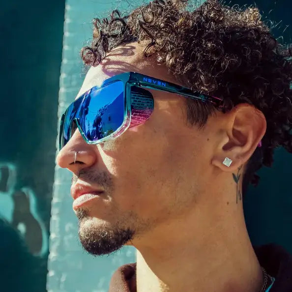 Neven Night Watch polarized sunglasses with blue mirrored lenses and a translucent teal frame worn by a man.