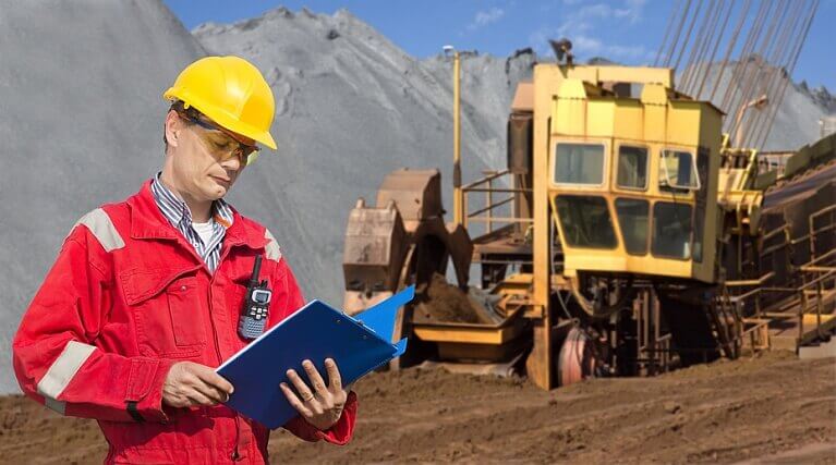 Worker wearing bifocal safety glasses while reading blue prints