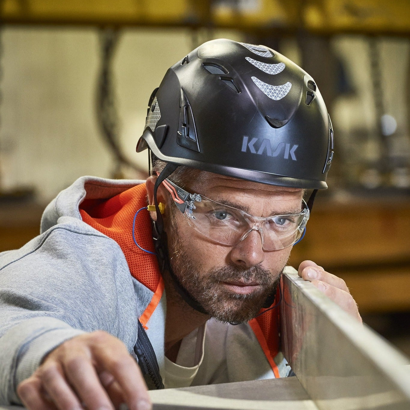 Bolle Silex Plus Small Safety Glasses with Orange/Gray Temples and Clear Platinum Anti-Fog Lens worn in the shop